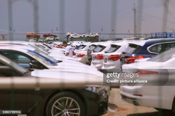 July 2018, China, Guangzhou: New cars of the company BMW are parked on a parking space at the Nansha trade zone at the port. Photo: Wenjun Chen/dpa