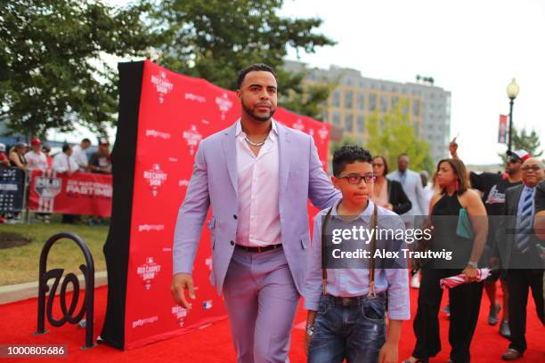 Nelson Cruz of the Seattle Mariners walks the carpet with his son during the MLB Red Carpet Show at Nationals Park on Tuesday, July 17, 2018 in...