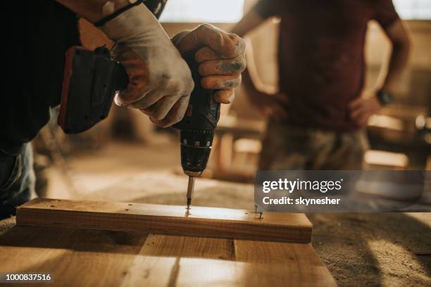 close up van onherkenbaar werknemer met behulp van boor tijdens het maken van meubels op houtklas schooljaar. - elektrisch gereedschap stockfoto's en -beelden