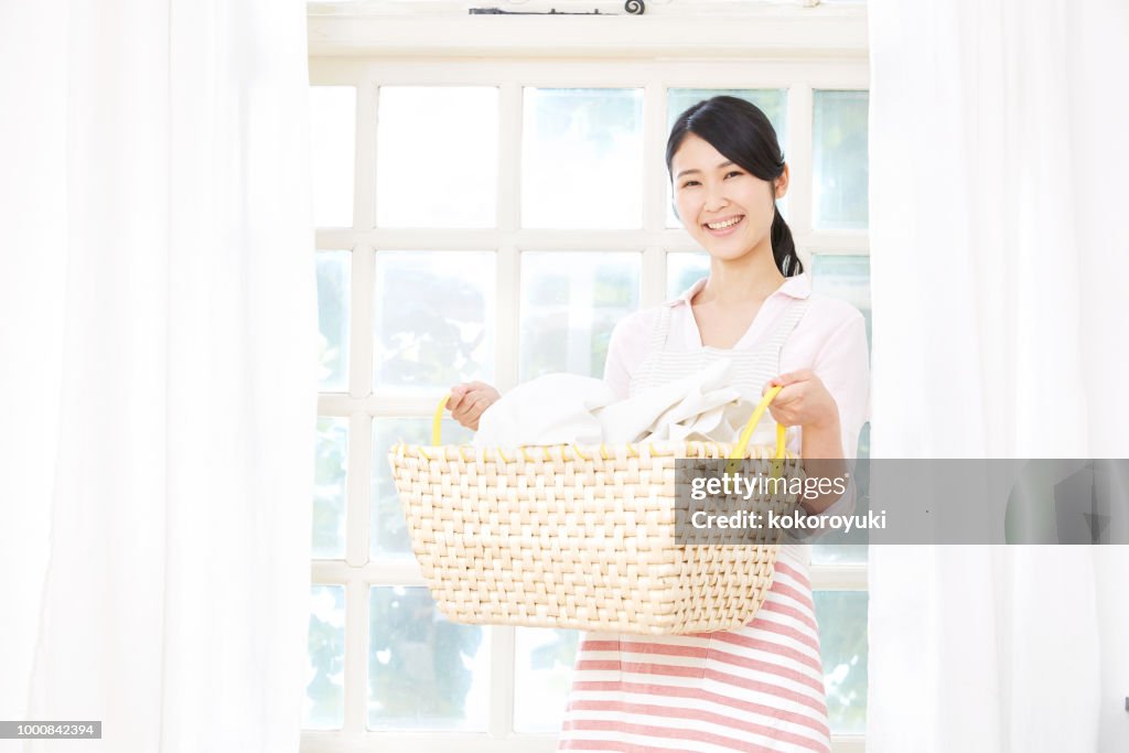 Smiling Asian woman with the laundry