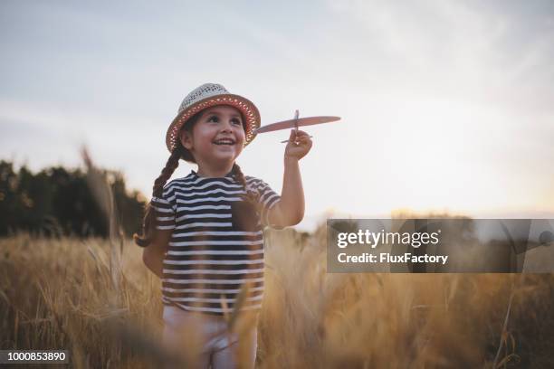 glückliches kind mit einem modellflugzeug - happy children playing outdoors stock-fotos und bilder