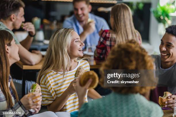 gelukkig studenten praten terwijl het hebben van lunch afbreken op cafetaria. - kantine stockfoto's en -beelden