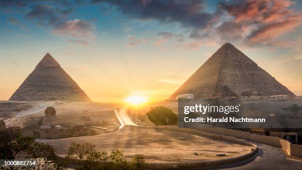 view of the great sphinx, pyramid of khafre and great pyramid of giza at sunset, cairo, giza, egypt - unesco georganiseerde groep stockfoto's en -beelden