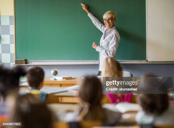 glücklich oberlehrer schreiben einen vortrag zum thema tafel an der elementary school. - baard stock-fotos und bilder