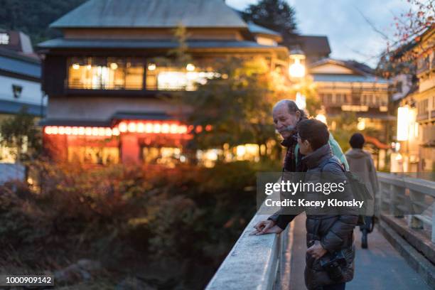 senior man and woman on bridge in hakone-yumoto japan at dusk - hakone kanagawa stock pictures, royalty-free photos & images