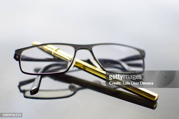 reflections of glasses and golden pen - gold meets golden fotografías e imágenes de stock