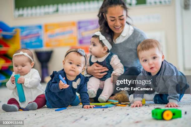 toddlers with their caretaker - nursery school child stock pictures, royalty-free photos & images