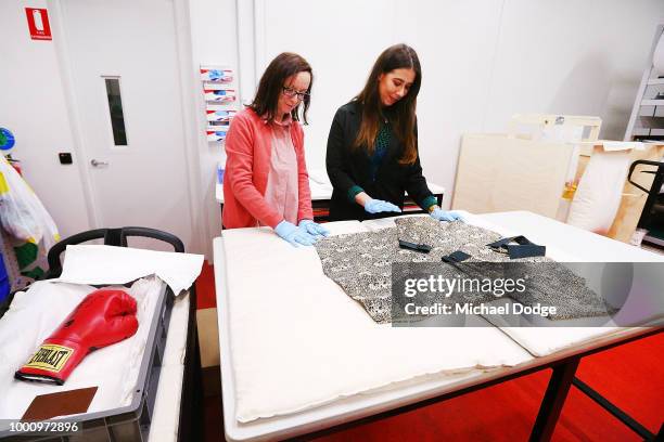 Handlers unveil a signed boxing glove and shirt worn by Nelson Mandela at Melbourne Museum on July 18, 2018 in Melbourne, Australia. Mandela My Life:...