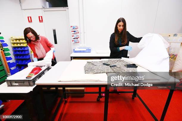 Handlers unveil a signed boxing glove and shirt worn by Nelson Mandela at Melbourne Museum on July 18, 2018 in Melbourne, Australia. Mandela My Life:...