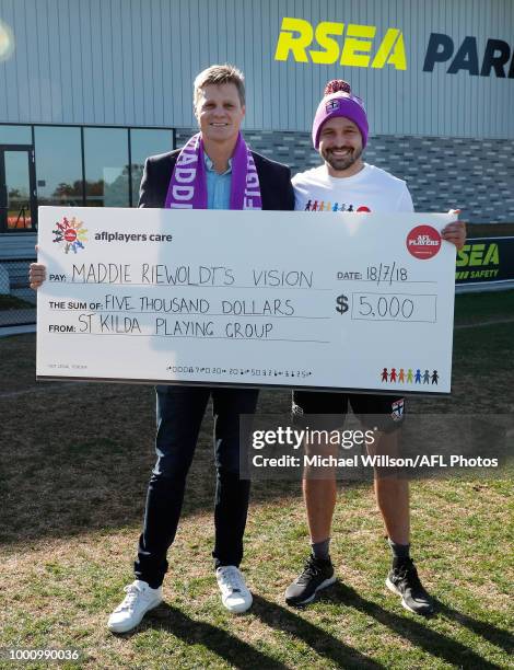 Jarryn Geary of the Saints and Nick Riewoldt pose for a photograph after a cheque for $5,000 from the AFLPA Players Care to Maddie Riewoldt's Vision...