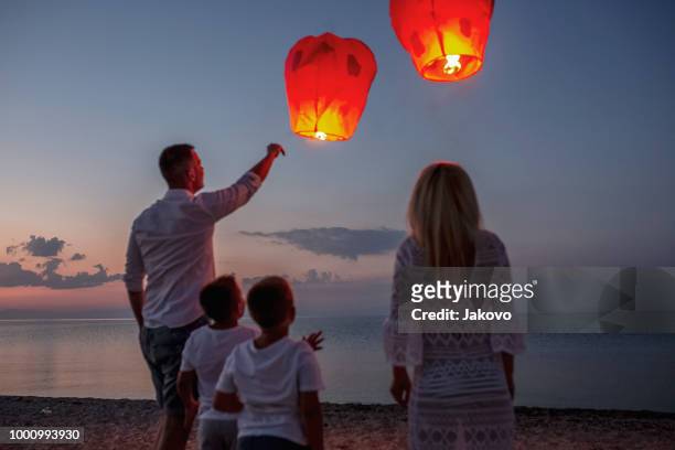 releasing paper lanterns by the sea - releasing stock pictures, royalty-free photos & images