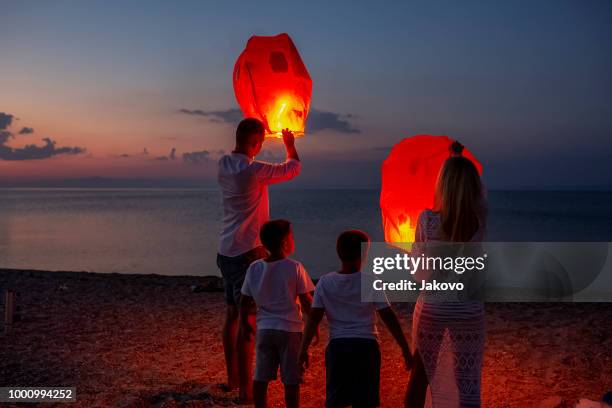 releasing paper lanterns by the sea - releasing lanterns stock pictures, royalty-free photos & images