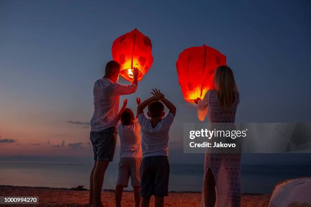 releasing paper lanterns by the sea - lantern imagens e fotografias de stock