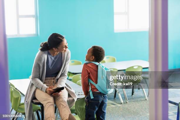 jongetje in de kleuterschool, in gesprek met de leraar - school boy with bag stockfoto's en -beelden