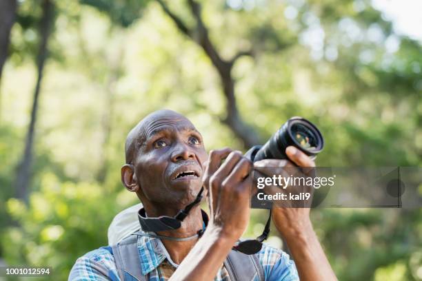 hombre senior afroamericano senderismo, con cámara - wow face man fotografías e imágenes de stock