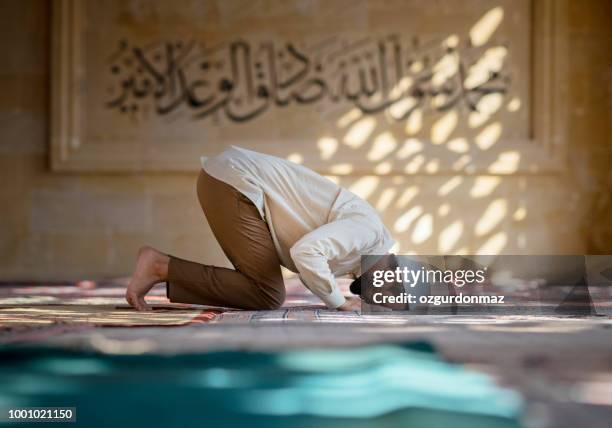 hombre está rezando en la mezquita - islamismo fotografías e imágenes de stock