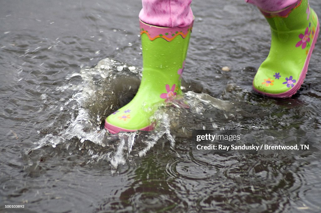 Green Galoshes Splashing In A Puddle