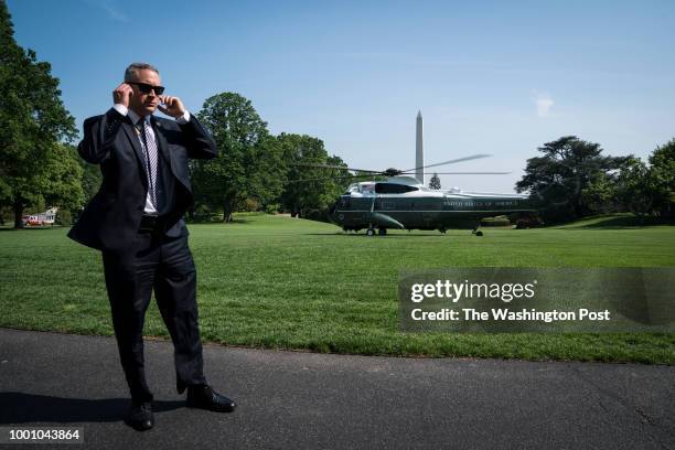 Member of the United States Secret Service stands guard as the Marine One helicopter carrying President Donald J. Trump departs heading to Walter...