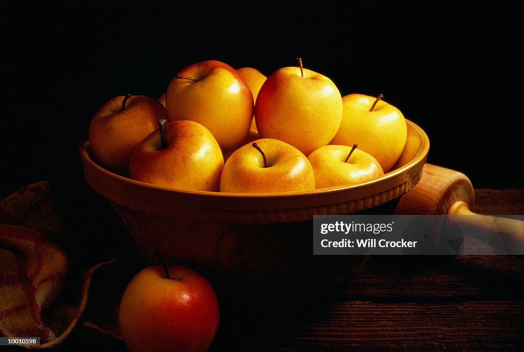 YELLOW APPLES IN BOWL BY ROLLING PIN