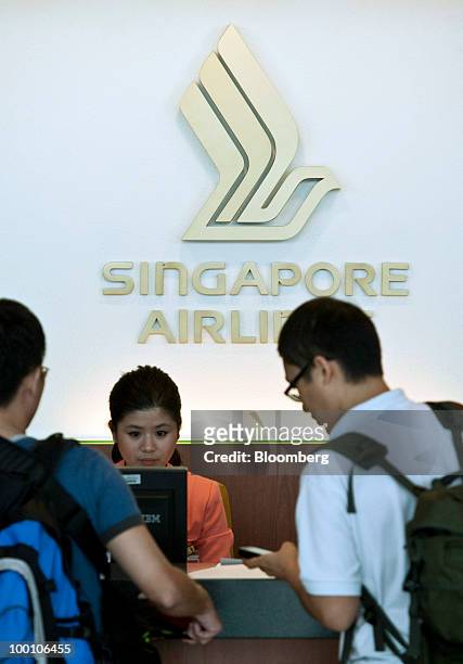 Passengers make inquiries at the Singapore Airlines Ltd. Information counter at Changi Airport in Singapore on Friday, May 21, 2010. Singapore...