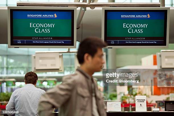 Passengers check-in for a Singapore Airlines Ltd. Flight at Changi Airport in Singapore on Friday, May 21, 2010. Singapore Airlines Ltd. Will...
