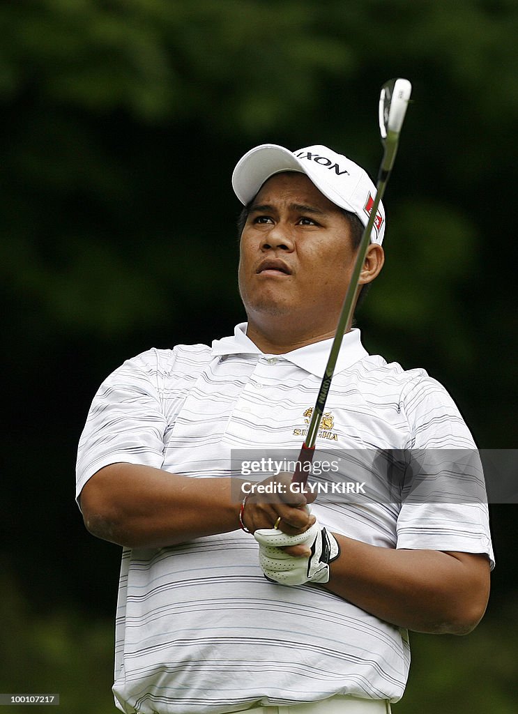 Thai golfer Chapchai Nirat watches his d