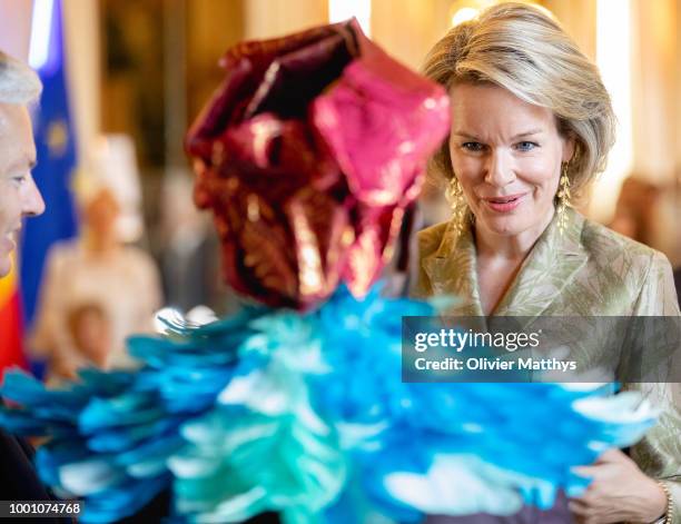 Queen Mathilde of Belgium talks to a musician during the official opening of the Africa Museum Exhibition at the Egmont Palace on July 18, 2018 in...