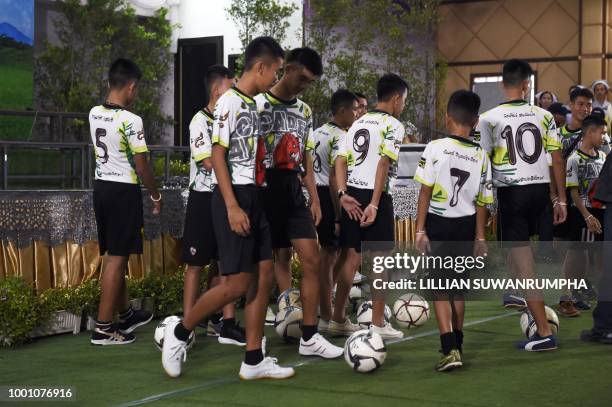 Some of the twelves boys, dramatically rescued from deep inside a Thai cave after being trapped for more than a fortnight, play with soccer balls...