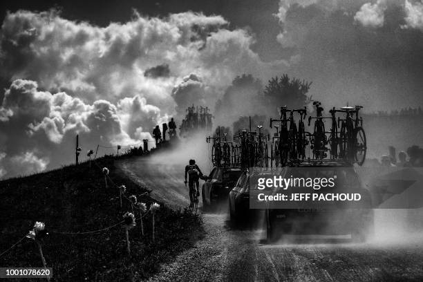 France's Fabien Grellier rides by his team's manager car in the ascent of Plateau des Glieres during the tenth stage of the 105th edition of the Tour...