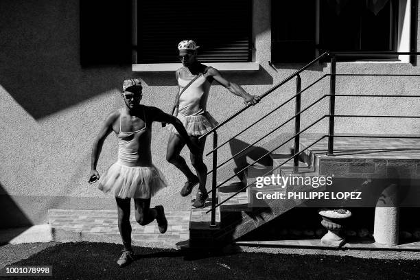 Spectators dressed in dancing tutu rush to watch the riders during the tenth stage of the 105th edition of the Tour de France cycling race between...