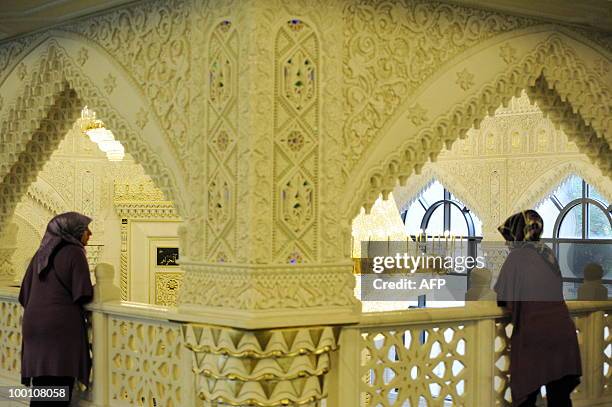 Two women wearing headscarves watch from a gallery of the new Omar Mosque in Berlin's Kreuzberg district during the inauguration of the Islamic...