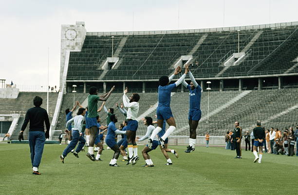 Mario Zagallo the coach for Brazil and the team trainer Admillo Chirol watch as Jairzinho and Marco Antonio in the foreground with the rest of the...
