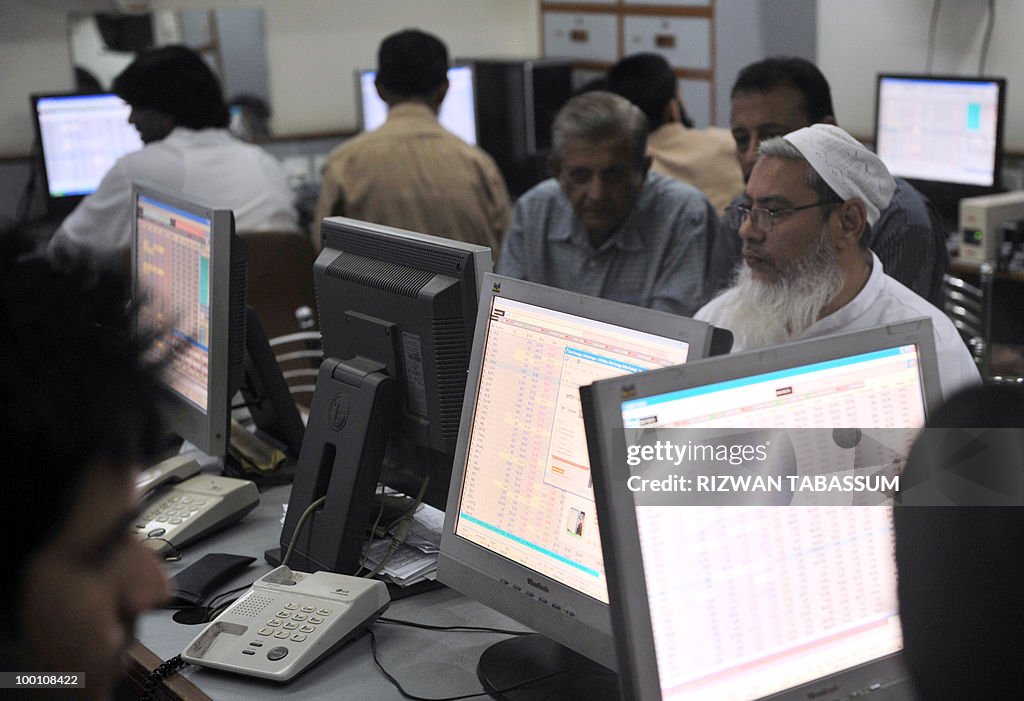 Pakistani stock dealers work at a broker