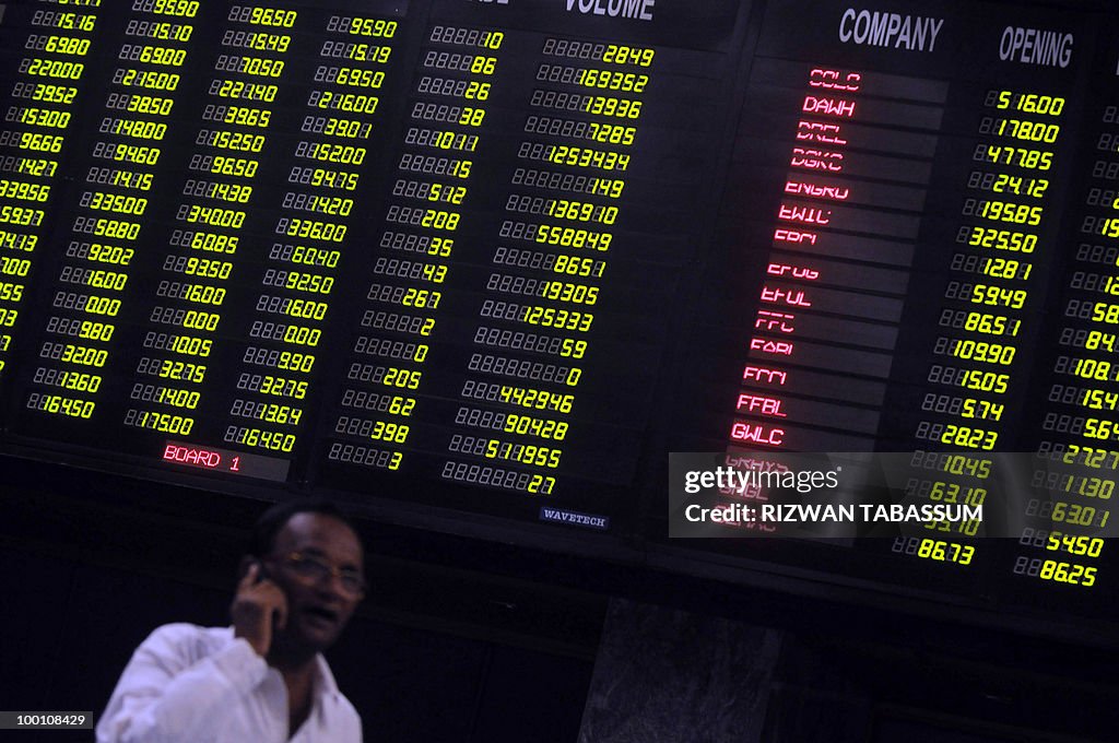 A Pakistani stockbroker talks on a phone