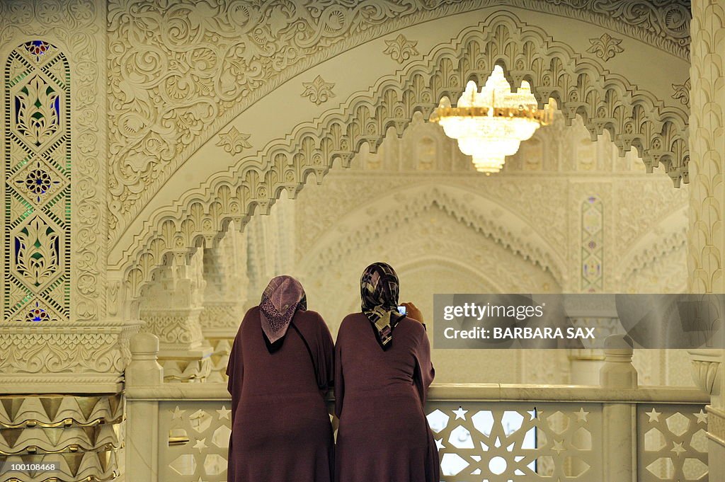 Two women wearing headscarves look from