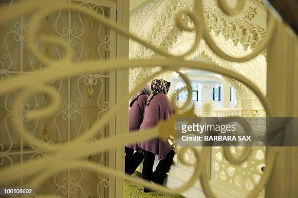 Two women wearing headscarves watch from a gallery of the new Omar Mosque in Berlin's Kreuzberg district during the inauguration of the Islamic...