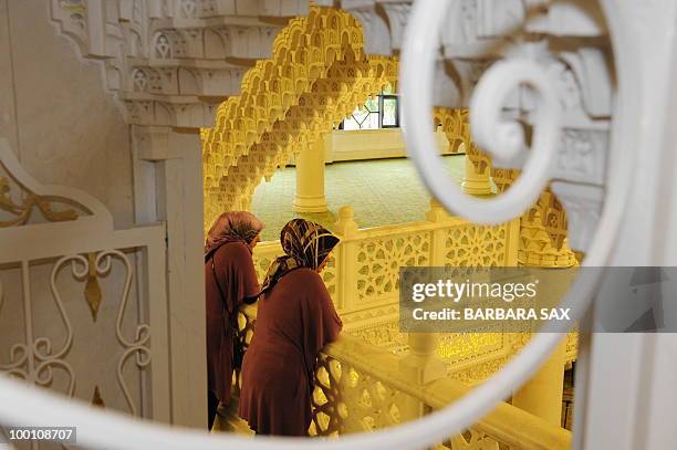 Two women wearing headscarves watch from a gallery of the new Omar Mosque in Berlin's Kreuzberg district during the inauguration of the Islamic...