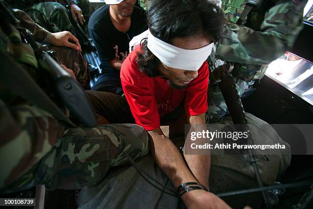 An anti-government protester 'Red Shirt' is detained by Thai security forces at Temple near their encampment on May 21, 2010 in Bangkok, Thailand....