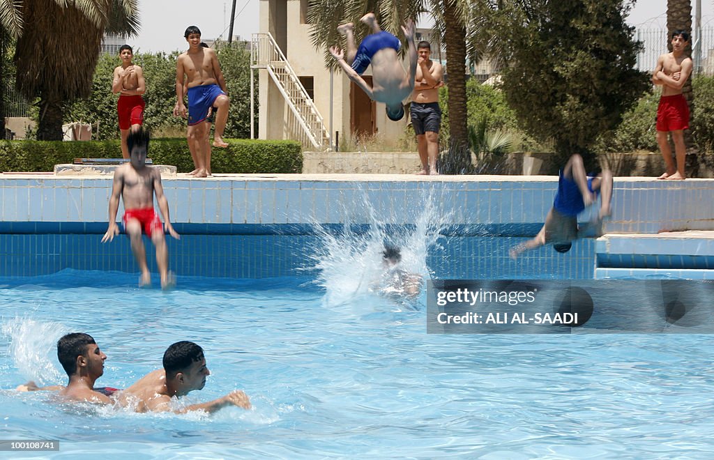 Iraqis cool off in a pool in Baghdad on