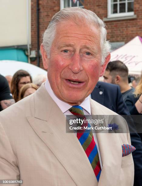 Prince Charles, Prince of Wales is offered Lemon cake with ants in on the "Yumbugs" stall during a visit to Honiton, and the town's 'Gate-to-Plate'...