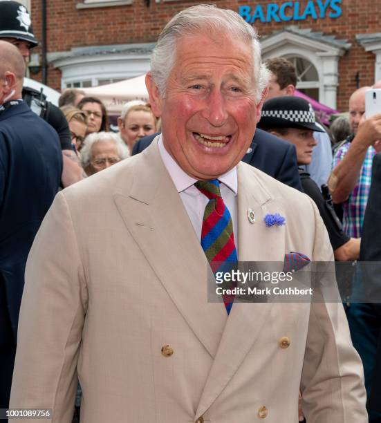 Prince Charles, Prince of Wales is offered Lemon cake with ants in on the "Yumbugs" stall during a visit to Honiton, and the town's 'Gate-to-Plate'...