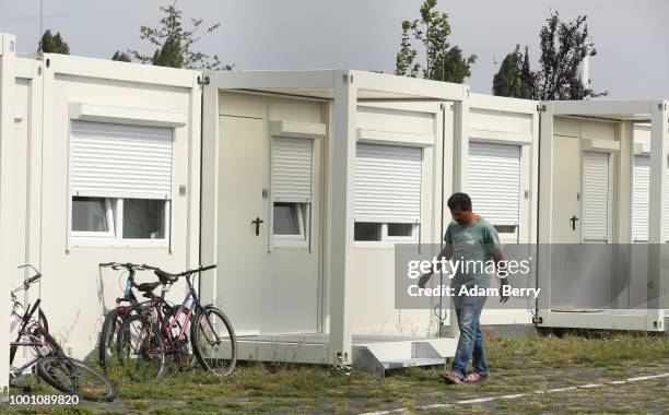 Refugee walks amidst containers used as a temporary refugee shelters at the former Tempelhof airport on July 18, 2018 in Berlin, Germany. Local...