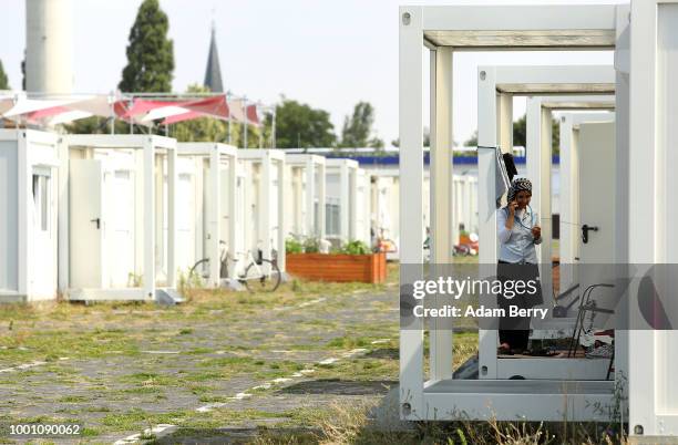 Refugee uses her mobile phone at a temporary refugee shelters at the former Tempelhof airport on July 18, 2018 in Berlin, Germany. Local politicians...
