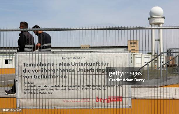 Security officers patrol a temporary asylum seeker reception center at the former Tempelhof airport on July 18, 2018 in Berlin, Germany. Local...