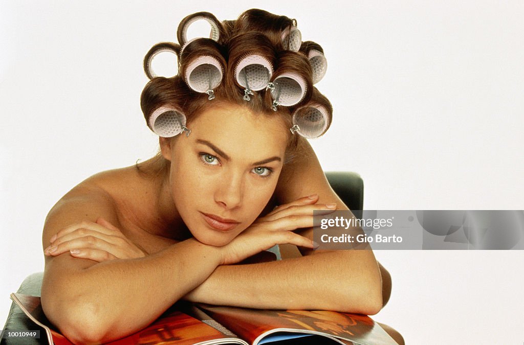 BARE SHOULDERED WOMAN WITH CURLERS IN HAIR