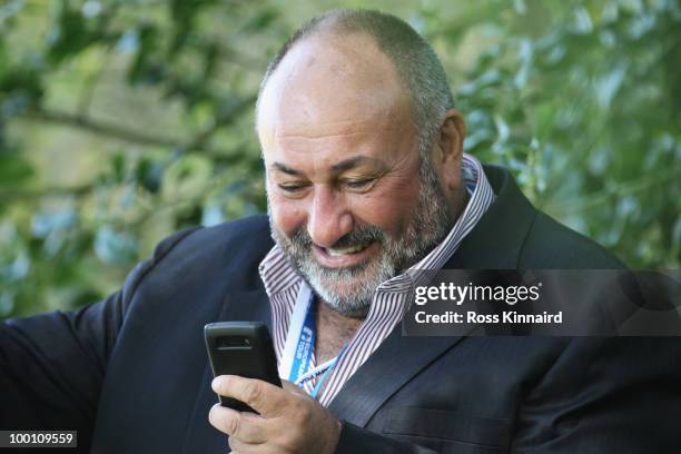 Businessman Andrew Chandler talks on the phone during the second round of the BMW PGA Championship on the West Course at Wentworth on May 21, 2010 in...