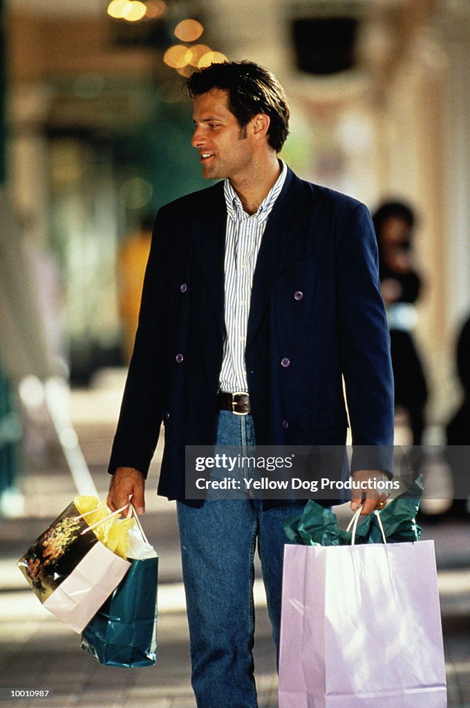 MAN WITH COLORFUL SHOPPING BAGS AT MALL