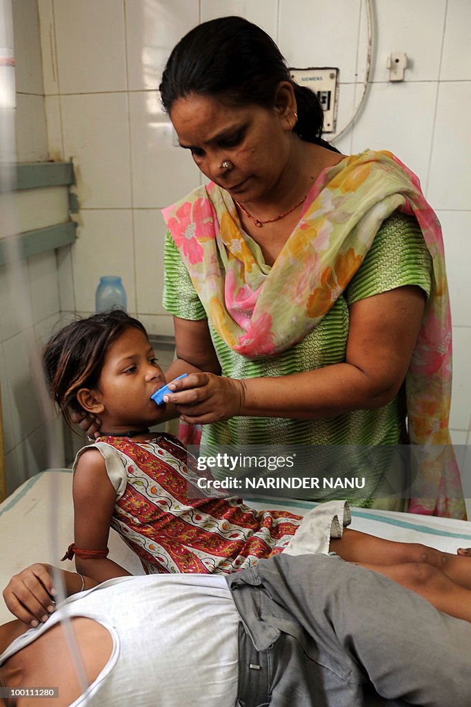 A relative gives water to child at the C