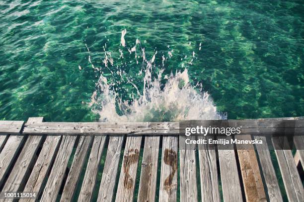 wet footprints on the edge of the wooden dock - jetty ストックフォトと画像