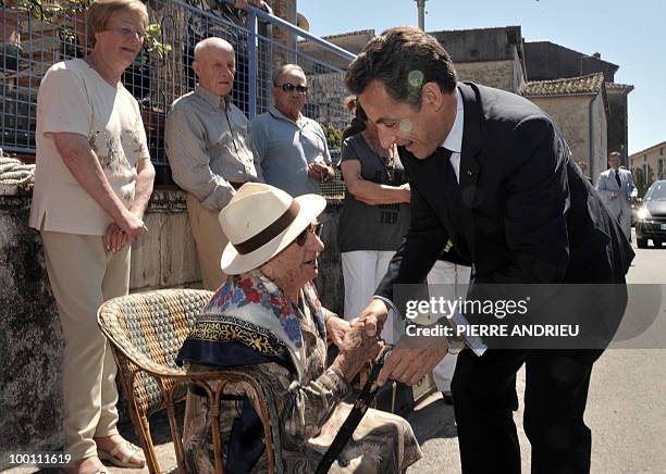 French President Nicolas Sarkozy shakes hands with a woman after visiting a local farm, on May 21, 2010 in Bouglon, southwestern France, during his...